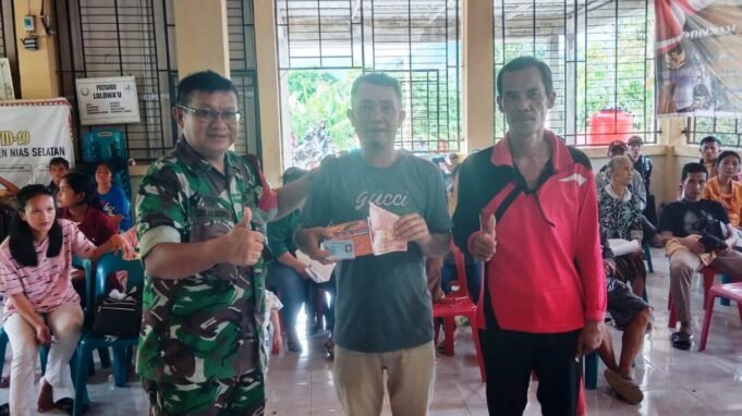 Koramil 10/Lolowau Beserta Babinsa, Menyerahkan Bantuan Tunai PKLWN di Balai Desa Lolowau Nias Selatan